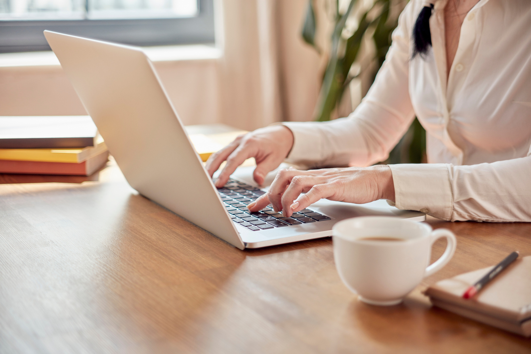 Home office working woman typing on laptop